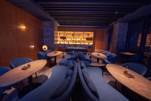 a restaurant with wooden tables and blue chairs at Ascott Rafal Olaya Riyadh in Riyadh