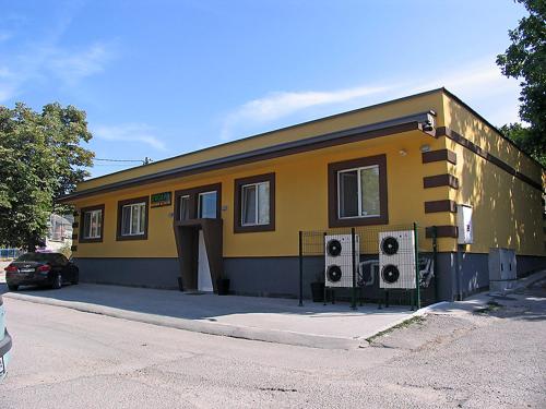 哈斯科沃的住宿－Хотел Хисаря，前面有两把扬声器的黄色建筑