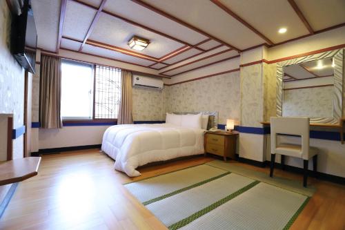 een slaapkamer met een bed, een tafel en een spiegel bij Phoenix Pavilion Hot Spring Hotel in Taipei