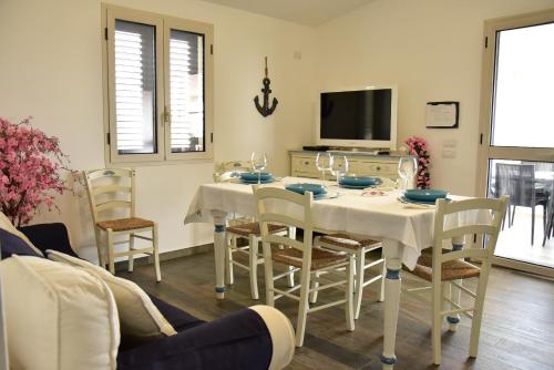 ein Esszimmer mit einem Tisch und Stühlen sowie einem TV in der Unterkunft Casa vacanza Lentisco D Sardegna Ogliastra in Tertenìa