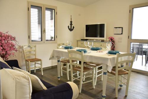 Un comedor con mesa y sillas y un televisor. en Casa vacanza Lentisco D Sardegna Ogliastra, en Tertenìa
