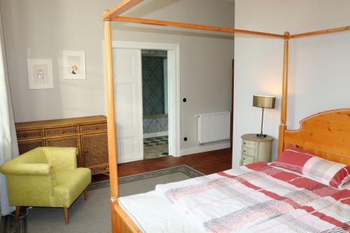 a bedroom with a canopy bed and a chair at 9-Personen-Fewo in Buchholz