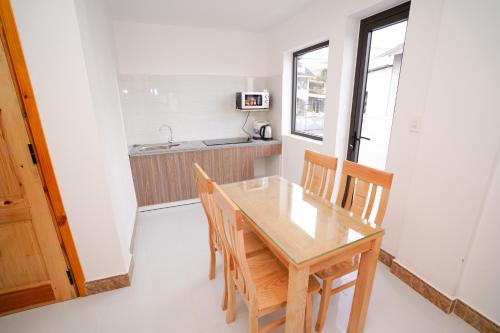 a small kitchen with a wooden table and chairs at S Villa Hotel in Da Thanh