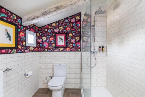 a bathroom with a toilet and a glass shower at Maison San Alfredo B&B in El Puig