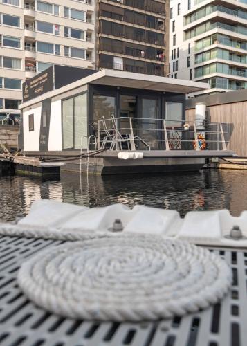 a boat is docked on the water with a dock at Houseboat-Oostende in Ostend