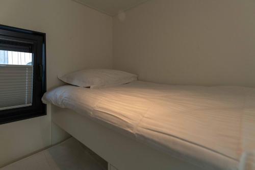 a bed in a small room with a window at Houseboat-Oostende in Ostend