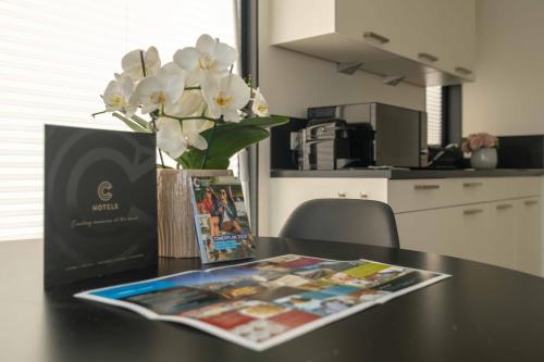 a table with a vase of flowers and a magazine at Houseboat-Oostende in Ostend