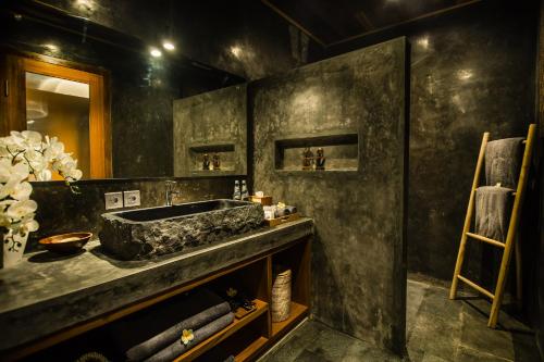 W łazience znajduje się kamienna umywalka i lustro. w obiekcie Ubud Season Villas w mieście Ubud