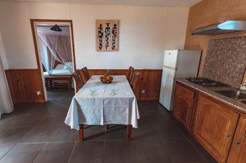 a kitchen with a table with a table cloth on it at Saint Leu - Bungalow avec PDJ piscine vue mer et montagne - Bardzour in Saint-Leu