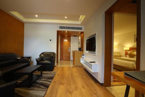 a living room with a couch and a bed at Best Western Plus Tejvivaan in Visakhapatnam