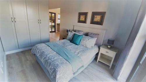 a bedroom with a bed with a blue comforter at Stoneridge farm in Plettenberg Bay