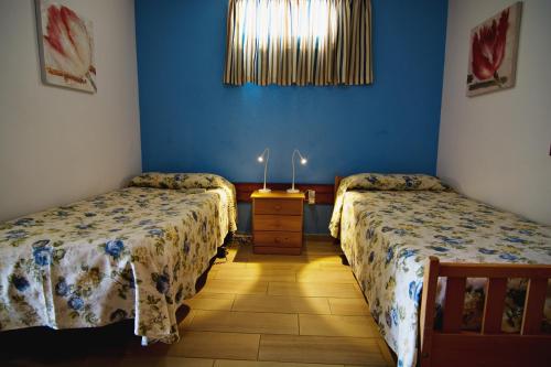 two beds in a room with blue walls at Casa Capitan con vista mar in Arona