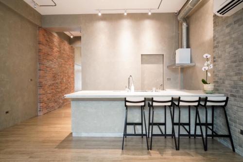 a kitchen with a counter with a sink and bar stools at Simple Living in Taitung City