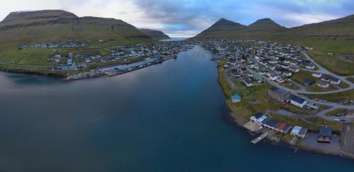 eine Luftansicht einer Stadt inmitten eines Wasserkörpers in der Unterkunft Panorama boathouse in Klaksvík