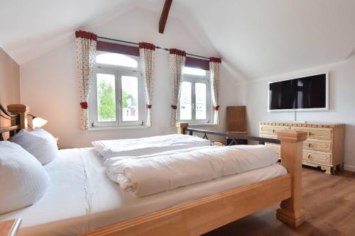 a bedroom with a large bed and a television at Villa Elisabeth Wohnung Bernstein in Heringsdorf