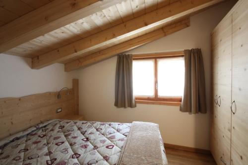 a bedroom with a bed and a window at Casa Mirandola Montana in Commezzadura