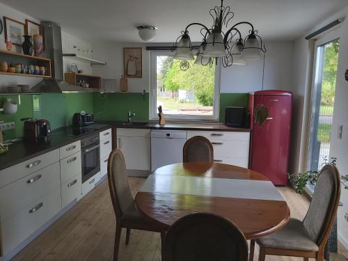 a kitchen with a wooden table and a red refrigerator at Ecki's Ferienhaus "KOMM an de BÄK" mit 5 Sternen bewertet bei Google und Traumferienwohnungen in Alt Schönau