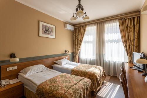 En eller flere senge i et værelse på Frapolli Hotel