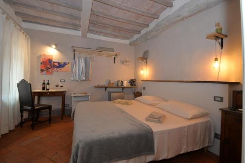 a bedroom with a bed and a desk and a chair at La Rughetta Guest House in Montepulciano