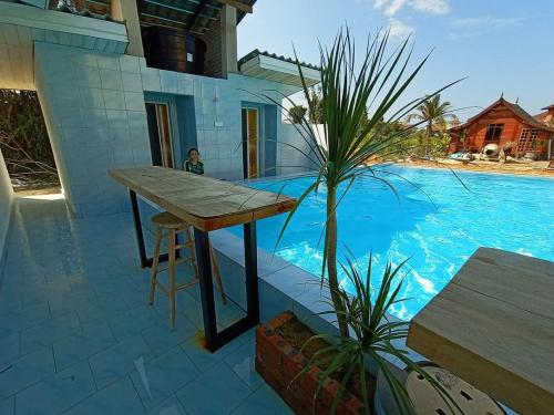 a table on a patio next to a swimming pool at The Serai Cottage Downtown Hotel in Kuala Terengganu