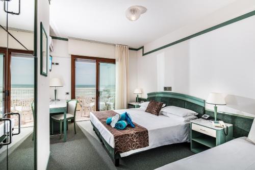 um quarto de hotel com uma cama e uma secretária em Hotel Atlantic em Lignano Sabbiadoro