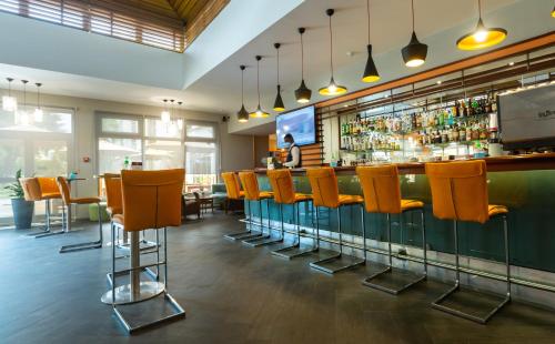 a bar with orange chairs in a restaurant at Accra City Hotel in Accra