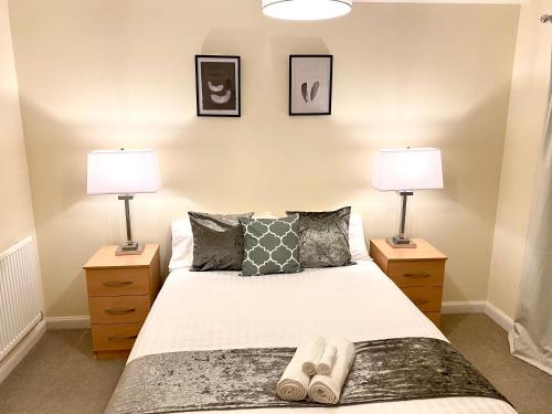 um quarto com 2 candeeiros e uma cama com chinelos em Superior Two-Bed Apartment with Free Parking, CV1 Coventry em Coventry