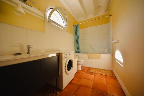 a bathroom with a washing machine and a toilet at Domaine de Gorre in Martillac