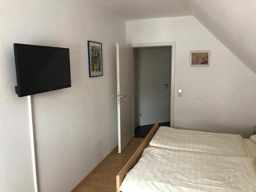 a bedroom with a bed and a flat screen tv at Pension Da Enzo in Otterbach
