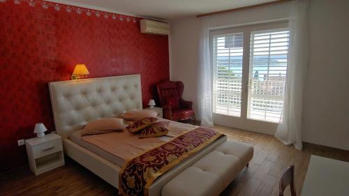 1 dormitorio con cama y pared roja en Villa Senegačnik, en Portorož