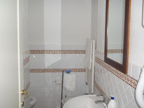uma casa de banho com um lavatório, um espelho e um WC. em B&B Alle Due Porte em Siena