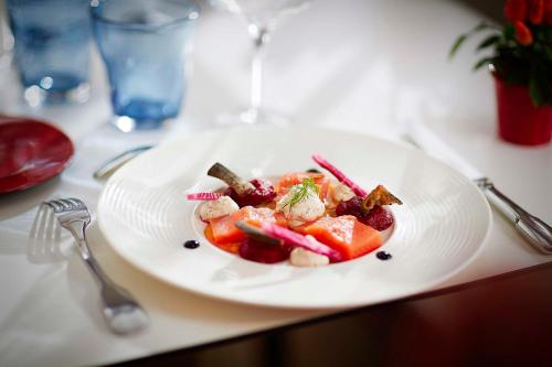 a plate of food with shrimp and vegetables on a table at La Commanderie de Champarey in Bourgoin