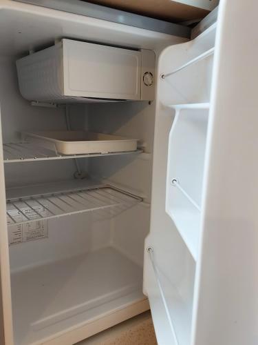 an empty refrigerator with its door open at Pretty Studio with a Private Terrace in London