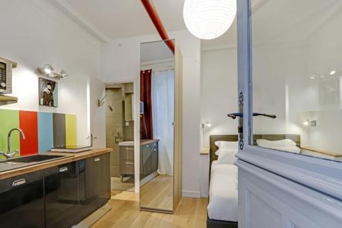 Cette chambre comprend une cuisine équipée d'un évier et d'un comptoir. dans l'établissement A Sweet Studio in Montparnasse - Boulevard du Montparnasse, à Paris
