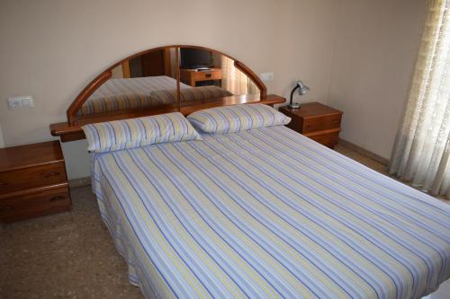 sypialnia z łóżkiem z drewnianym zagłówkiem w obiekcie Casa Serra - PATERNA - APARTAMENTO ALQUILA 3 HABITACIONES CON GARAJE w mieście Paterna