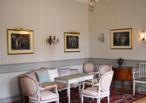 a room with chairs and a table and a table and chairs at Ronnums Herrgård in Vargön