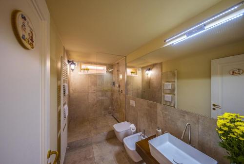 a bathroom with a sink and a toilet and a mirror at Foresteria Bergamo Bella B&B in Bergamo