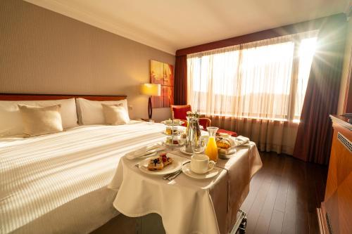 a hotel room with a bed with a table with food on it at InterContinental Budapest, an IHG Hotel in Budapest