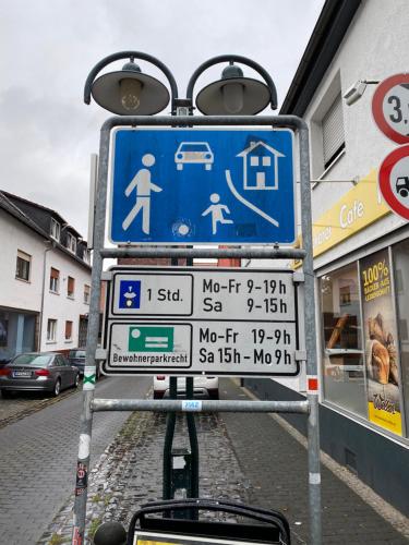 a street sign with many signs on a street at Hexenhäuschen Dreieichenhain in Dreieich