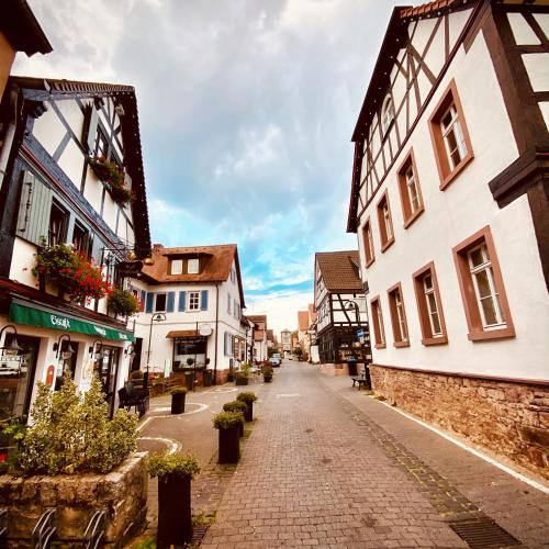 an empty street in a town with buildings at Hexenhäuschen Dreieichenhain in Dreieich