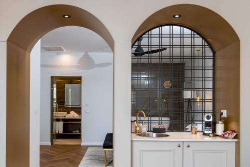 una cocina con un arco que conduce a una cocina con fregadero en Alonella, en Kefar Weradim