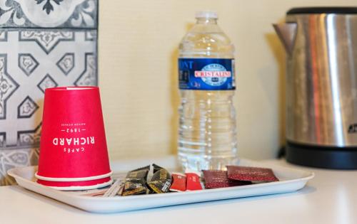 a bottle of water sitting next to a plate of food at La Commanderie de Champarey in Bourgoin