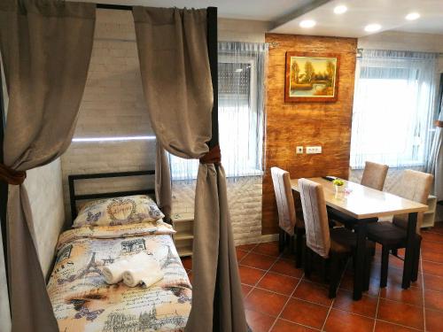 um quarto com uma cama e uma mesa com cadeiras em Vila Violeta em Šabac