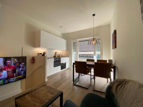 a living room with a table and a kitchen at Stylish house in the heart of Breda city center in Breda