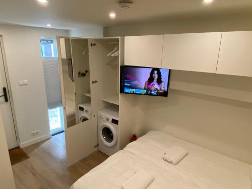 a bedroom with a bed with a tv on the wall at Stylish house in the heart of Breda city center in Breda