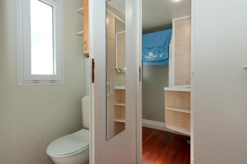 a bathroom with a toilet and a window at Club del Sole Adriano Family Collection in Punta Marina