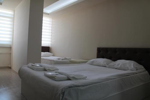 فندق Abro Necatibey في أنقرة: غرفة نوم بسرير كبير عليها شراشف ووسائد بيضاء