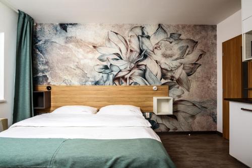 a bedroom with a mural of flowers on the wall at Apartmán Lenka in Veľký Meder