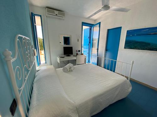 Hotel Guitgia Tommasino في لامبيدوسا: غرفة نوم مع سرير مع دمية دب عليها