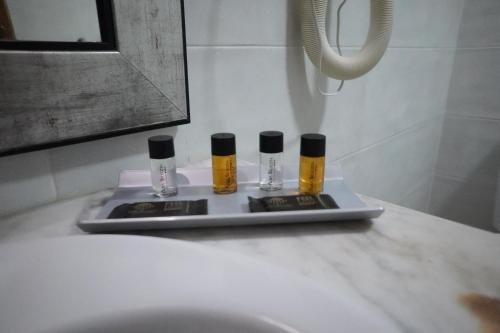 Hotel Alba Seleqtta في يوريت دي مار: مغسلة الحمام عليها ثلاث زجاجات من الزيوت الاساسية